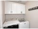 Well-organized laundry room with overhead cabinets and side-by-side washer and dryer at 325 W San Angelo St, Gilbert, AZ 85233