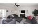 Comfortable living room with gray sofas, a ceiling fan, and a mounted flat-screen television at 325 W San Angelo St, Gilbert, AZ 85233