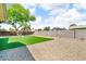 Large backyard is landscaped with lawn, mature tree, and low-maintenance stone, perfect for outdoor living at 332 E Houston Ave, Gilbert, AZ 85234
