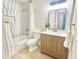 Well-lit bathroom featuring a vanity, a decorative mirror, and a tiled shower and tub combo at 332 E Houston Ave, Gilbert, AZ 85234