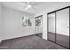 Bright bedroom featuring mirrored closet doors, a ceiling fan, and a window offering plenty of natural light at 332 E Houston Ave, Gilbert, AZ 85234