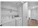 Well-lit laundry room with washer, dryer, and shelving for storage at 332 E Houston Ave, Gilbert, AZ 85234