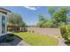 Well-maintained backyard features a manicured lawn, mature trees, and a secure fence at 3386 E Strawberry Dr, Gilbert, AZ 85298