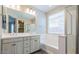 Bright bathroom featuring dual sinks, a soaking tub, and a separate walk-in shower at 3386 E Strawberry Dr, Gilbert, AZ 85298