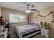 Bedroom features a ceiling fan, window, and white nightstand with decor at 3411 W Redfield Rd, Phoenix, AZ 85053