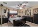Bedroom with a ceiling fan, dark wood furniture, and a cozy atmosphere for relaxation at 3411 W Redfield Rd, Phoenix, AZ 85053