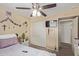 Cozy bedroom featuring a ceiling fan, closet, and a wall-mounted TV for relaxation and convenience at 3411 W Redfield Rd, Phoenix, AZ 85053