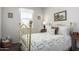 Bright bedroom features a golden bed frame, soft natural light, and a charming white quilt at 36204 W San Sisto Ave, Maricopa, AZ 85138