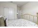 Well-lit bedroom with a golden bed frame, white sliding closet doors, and neutral-toned walls at 36204 W San Sisto Ave, Maricopa, AZ 85138