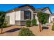 Home exterior showcasing desert landscaping with mature trees and shrubs, plus shuttered windows at 36204 W San Sisto Ave, Maricopa, AZ 85138