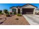 Charming single story home with a brown two car garage and colorful desert landscaping at 36204 W San Sisto Ave, Maricopa, AZ 85138