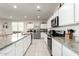 Bright kitchen with white cabinets, granite countertops, and stainless steel appliances at 36204 W San Sisto Ave, Maricopa, AZ 85138