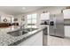 Bright open kitchen with stainless steel appliances and a large granite island with a sink at 36204 W San Sisto Ave, Maricopa, AZ 85138