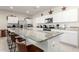 Modern kitchen with white cabinets, stainless steel appliances, and a large granite island at 36204 W San Sisto Ave, Maricopa, AZ 85138