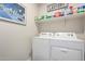 Well-organized laundry room equipped with a washer, dryer, and storage shelf at 36204 W San Sisto Ave, Maricopa, AZ 85138