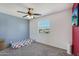 A spacious bedroom with a large window offering natural light and ceiling fan, carpet flooring, and wall-mounted television at 3732 W Bluefield Ave, Glendale, AZ 85308