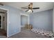 A modern bedroom with light blue walls, ceiling fan, mirrored closet doors, carpet flooring, and natural light at 3732 W Bluefield Ave, Glendale, AZ 85308