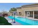 Backyard pool with safety gate and exterior view of home and sunny skies at 3732 W Bluefield Ave, Glendale, AZ 85308