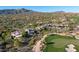 Scenic aerial of the property surrounded by desert landscape with a lush green golf course nearby and mountain backdrop at 39541 N 107Th Way, Scottsdale, AZ 85262