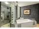 Elegant bathroom with a standalone soaking tub, glass brick window, and a walk-in shower at 39541 N 107Th Way, Scottsdale, AZ 85262