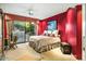 Spacious bedroom with red accent wall, patterned bedding, and sliding glass door to patio at 39541 N 107Th Way, Scottsdale, AZ 85262