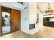 Foyer with a fireplace and built-in shelving, complemented by a wooden door and desert landscaping at 39541 N 107Th Way, Scottsdale, AZ 85262