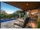 Relaxing covered patio overlooking a pool and desert landscaping, with comfortable seating and dining area at 39541 N 107Th Way, Scottsdale, AZ 85262