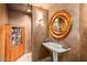 Charming powder room boasting a pedestal sink, decorative mirror, and unique wall texture at 39541 N 107Th Way, Scottsdale, AZ 85262