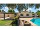 View of the back exterior of the home with a covered patio, garden, grass, and swimming pool at 4034 E Aster Dr, Phoenix, AZ 85032
