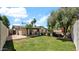 Spacious backyard with a well-maintained lawn, mature trees, a covered patio, and a fenced-in swimming pool at 4034 E Aster Dr, Phoenix, AZ 85032