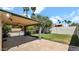The covered patio looks onto the large lawn and swimming pool in this well-maintained backyard at 4034 E Aster Dr, Phoenix, AZ 85032