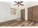 A comfortable bedroom featuring wood floors, a ceiling fan, closet, and a window at 4501 E Carol Ave # 68, Mesa, AZ 85206