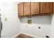 Bright laundry room includes modern flooring and convenient overhead cabinets for ample storage at 4501 E Carol Ave # 68, Mesa, AZ 85206