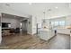 Open-concept kitchen flows into the living area with wood-look tile floors and white cabinetry throughout at 4619 N 179Th Dr, Goodyear, AZ 85395