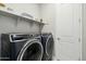 Modern laundry room featuring front load washer and dryer, storage shelves, and clean, functional space at 4619 N 179Th Dr, Goodyear, AZ 85395