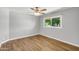 Bedroom showcasing wood-look flooring, a ceiling fan, and a window with natural light at 4735 S Mill Ave, Tempe, AZ 85282