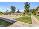 A community view with a pool, grassy area, and palm trees on a sunny day at 4735 S Mill Ave, Tempe, AZ 85282