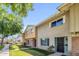 View of tan and brown two-story townhouse with brick facade, sidewalk and green lawn at 4735 S Mill Ave, Tempe, AZ 85282