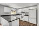 Bright kitchen featuring white cabinets, gray counters, stainless steel sink and appliances, and wood-look flooring at 4735 S Mill Ave, Tempe, AZ 85282