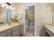 Well-lit bathroom featuring a dual-sink vanity, a tile floor, and a shower, offering a spa-like experience at 5337 W Diana Ave, Glendale, AZ 85302