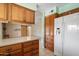 Well-appointed kitchen boasting wooden cabinets, modern appliances, and an open layout leading to living area at 5337 W Diana Ave, Glendale, AZ 85302