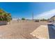 Large gravel backyard surrounded by a block wall and showcasing some desert landscaping at 5452 E University Dr, Mesa, AZ 85205