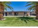 Beautiful home with a green lawn and mature palm trees provides a tropical, inviting feel at 5452 E University Dr, Mesa, AZ 85205