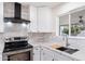 Stylish white kitchen featuring stainless steel appliances, white backsplash, and attractive countertops at 5452 E University Dr, Mesa, AZ 85205
