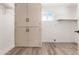 Bright laundry room with tile floors, a built-in cabinet for storage, and a window to let in natural light at 5452 E University Dr, Mesa, AZ 85205