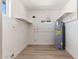 A utility room features sleek wood-look tile flooring, white brick walls, and two windows offering ample natural light at 5452 E University Dr, Mesa, AZ 85205
