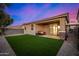 This backyard features lush artificial turf and a covered patio for relaxation and entertainment at 5752 N 109Th Ave, Phoenix, AZ 85037