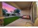 Inviting backyard featuring artificial turf, desert landscaping, and a covered patio with comfortable seating at 5752 N 109Th Ave, Phoenix, AZ 85037