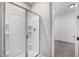 Bathroom shower featuring glass doors and white tile surround at 5752 N 109Th Ave, Phoenix, AZ 85037