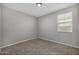 An empty bedroom featuring neutral colored walls, carpet and a window at 5752 N 109Th Ave, Phoenix, AZ 85037